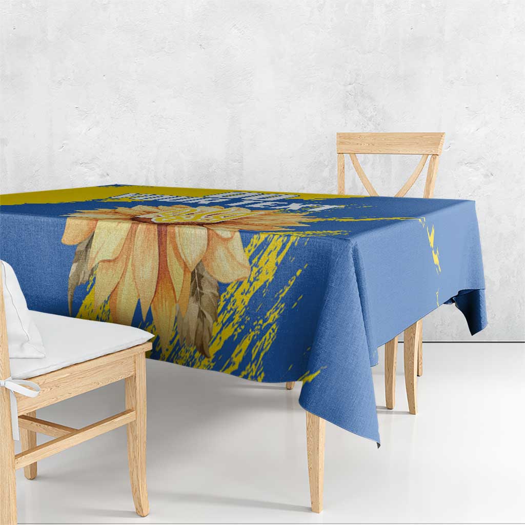 Blue and yellow tablecloth draped on table with sunflower and trident artwork