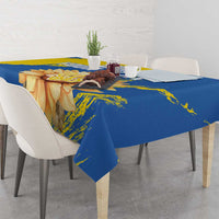 Blue and yellow tablecloth on table with sunflower, trident, and grunge accents