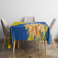 Blue and yellow tablecloth with sunflower and trident design on tabletop