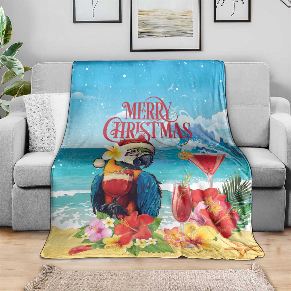 Blue tropical Christmas blanket on sofa, featuring parrot, flowers, and cocktail glasses