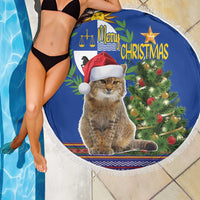 Blue round Christmas beach blanket with white fringe, cat in Santa hat with glowing Christmas tree