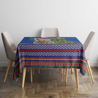 Blue Christmas tablecloth with multicolor folk stripe pattern and small holiday centerpiece