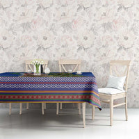 Blue Christmas tablecloth with multicolor folk stripe pattern on dining table with chairs