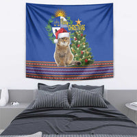 Blue Christmas tapestry showing cat, decorated tree, and colorful folk border stripe