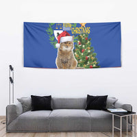 Blue Christmas tapestry with cat wearing Santa hat beside decorated tree