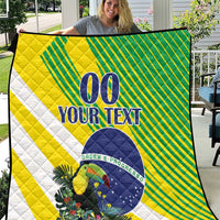 Outdoor display of yellow-green and white quilt with blue “00 YOUR TEXT” and toucan floral detail