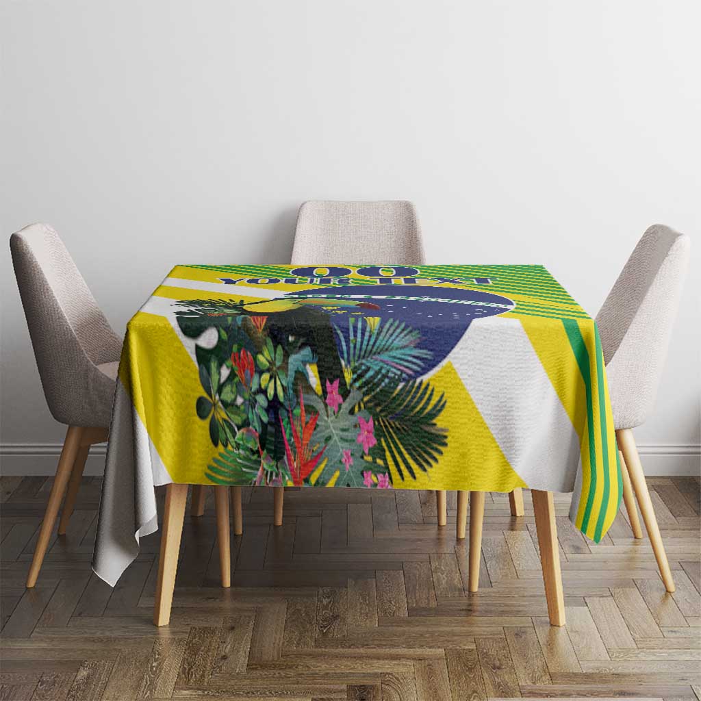 Green, yellow, and blue tropical tablecloth with leafy print and striped geometric accents