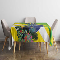 Green, yellow, and blue tropical tablecloth with leafy print and striped geometric accents