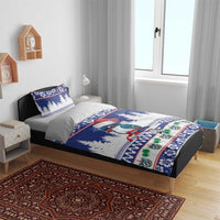 Blue holiday duvet and pillowcases with bird in Santa hat, pine trees, and festive stripes