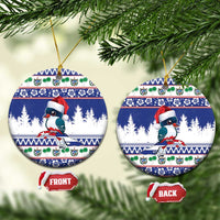 Blue round ceramic Christmas ornament with cartoon bird wearing Santa hat