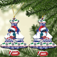 Blue ceramic bell-shaped ornament set with bird wearing Santa hat, hanging on tree