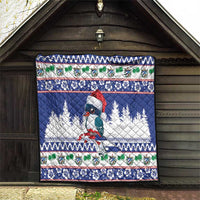 Blue quilt blanket hanging in doorway with bird, pine trees, and holiday stripes