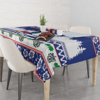 Blue Christmas tablecloth on dining table with bird motif, evergreen trees, and red edging