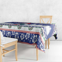 Blue Christmas tablecloth with floral and tree pattern, draped over table edge