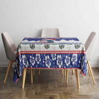 Blue Christmas tablecloth covering table with floral border and red-green accents