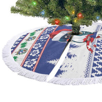 Folded view of blue round fringed tree skirt with tropical bird, palm and snowflake prints