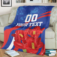 Custom lapageria blanket on armchair, blue with red stripe and red flowers, '00 YOUR TEXT'.