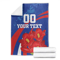Custom lapageria blanket with folded stack; blue/red/white with red flowers and '00 YOUR TEXT'.