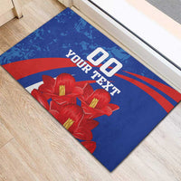 Blue rubber doormat with red stripe arcs, red flower cluster, and custom text