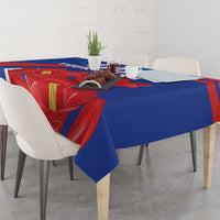 Blue tablecloth with red floral print and yellow accents draped over the table.
