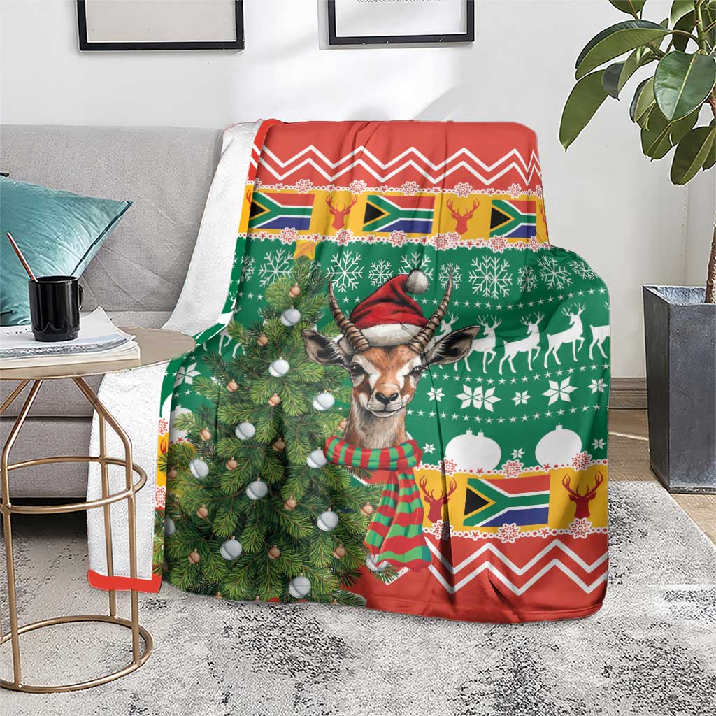 Christmas blanket over chair, green and red festive springbok scene with pine and snow balls