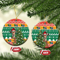 Round ceramic Christmas ornament with springbok in a red hat and festive green pattern