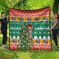 Decorative Christmas quilt blanket with green farm-style pattern, springbok, and red zigzag border
