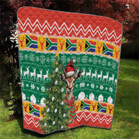 Quilt blanket showing green Christmas tree with springbok, white ornaments, and red zigzag top border