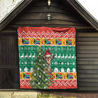 Quilt blanket hanging in doorway, green festive scene with springbok and red zigzag trim