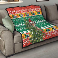 Christmas quilt blanket on sofa with green center scene, springbok, and red zigzag edging