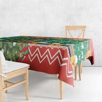 Christmas tablecloth over table edge, green and red with zigzag and holiday icons