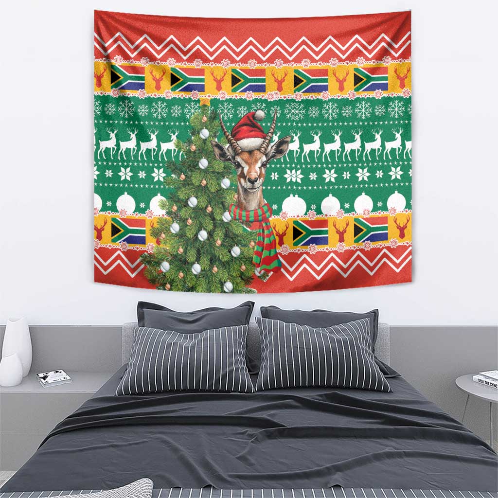 Hanging Christmas tapestry featuring a springbok with antlers, red hat and colorful holiday border