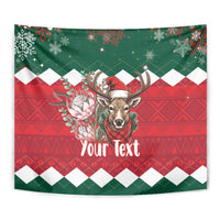 Close-up of green and red Christmas tapestry showing springbok antlers and “Your Text”.