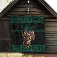 Green Christmas quilt hung in barn with Krampus barrel artwork and geometric trim