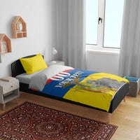 Bedding set on bed with flag-style yellow, red, and blue comforter; "00 YOUR TEXT" print.