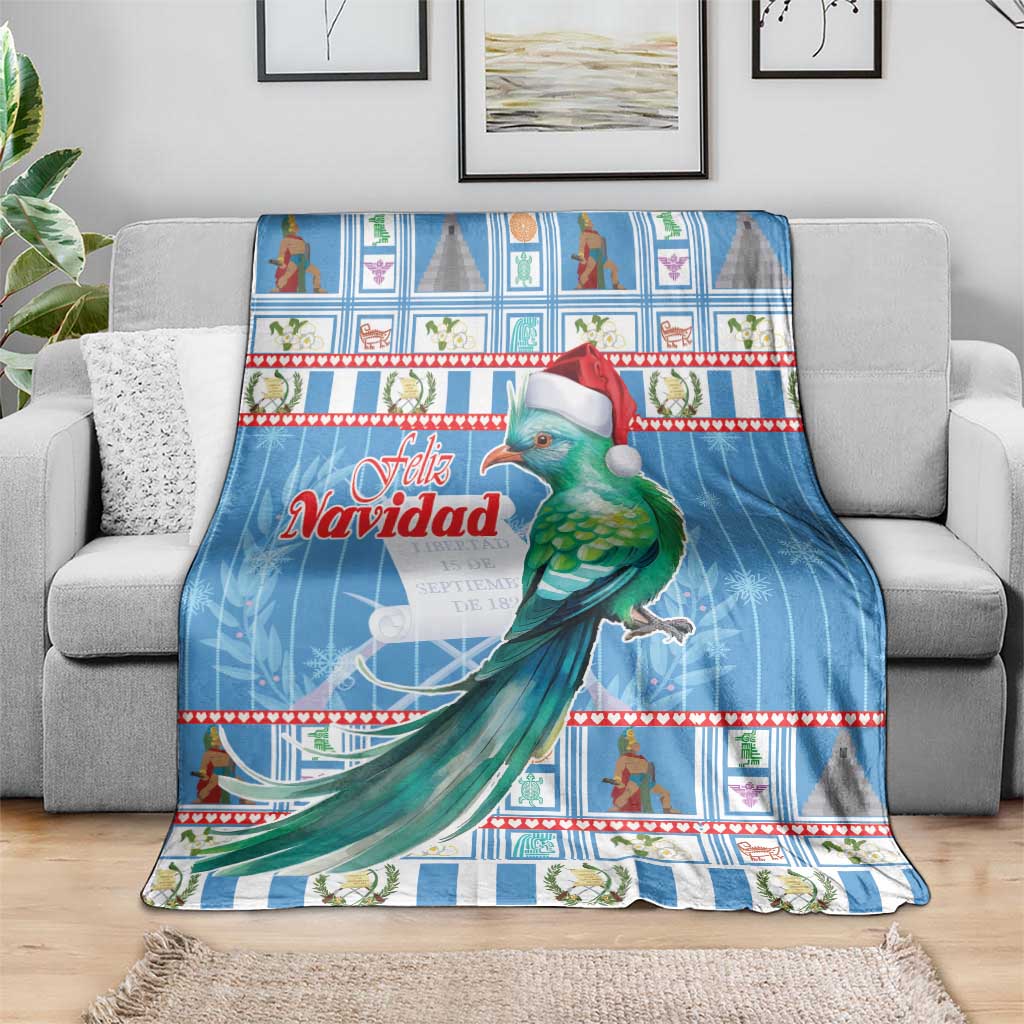 Blue Christmas throw blanket on gray sofa, green bird with red Santa hat