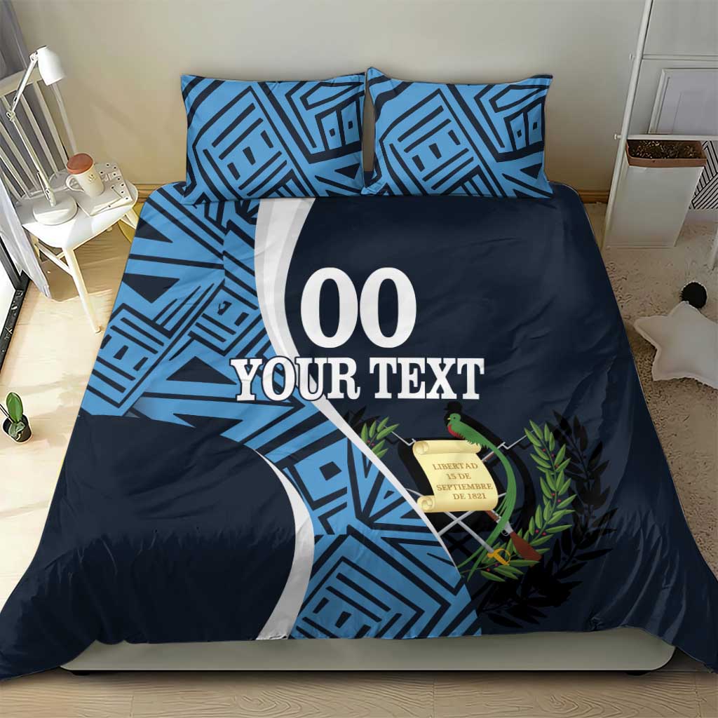 Blue geometric pillowcases and navy duvet with large '00 YOUR TEXT' print and decorative leaf detail