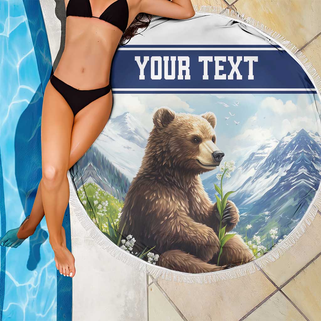 Round beach blanket with tassel fringe, brown bear artwork with 'YOUR TEXT' blue top stripe