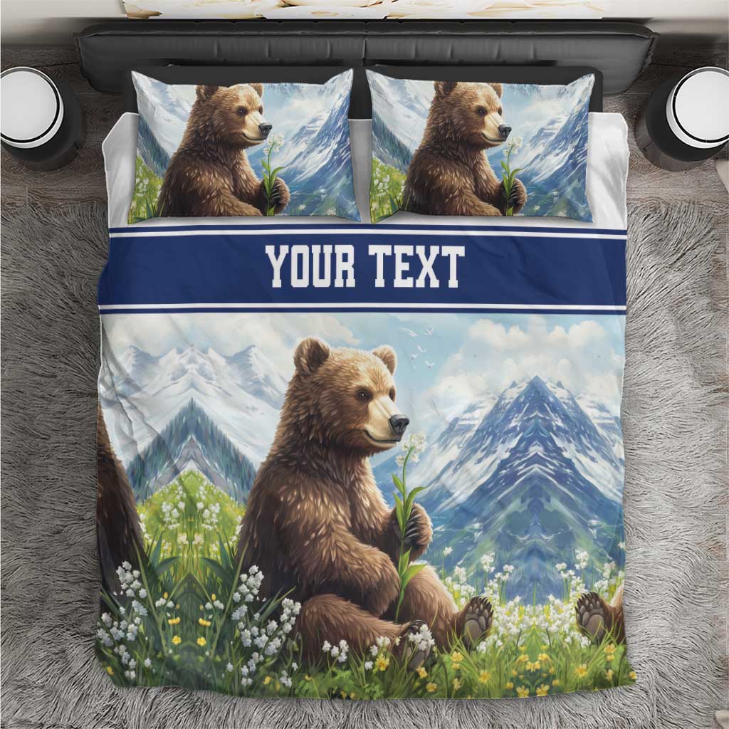 Blue bedding set with brown bear and floral garden print, plus blue band reading “YOUR TEXT”.