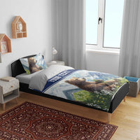 Blue duvet bedding set on bed frame with brown bear print, mountains, and “YOUR TEXT” band.