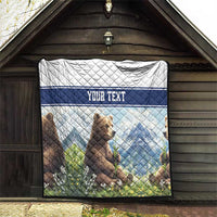 Quilt blanket with bear cubs, blue mountain artwork, and 'YOUR TEXT' on quilt
