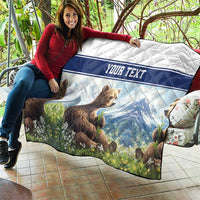 Quilt blanket with bear cubs, blue landscape print, flowers, and 'YOUR TEXT' banner