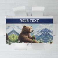 Personalized tablecloth with blue border, brown bear, and lily-of-the-valley flowers