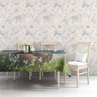 Tablecloth featuring brown bear and blooming meadow plants with blue border on table