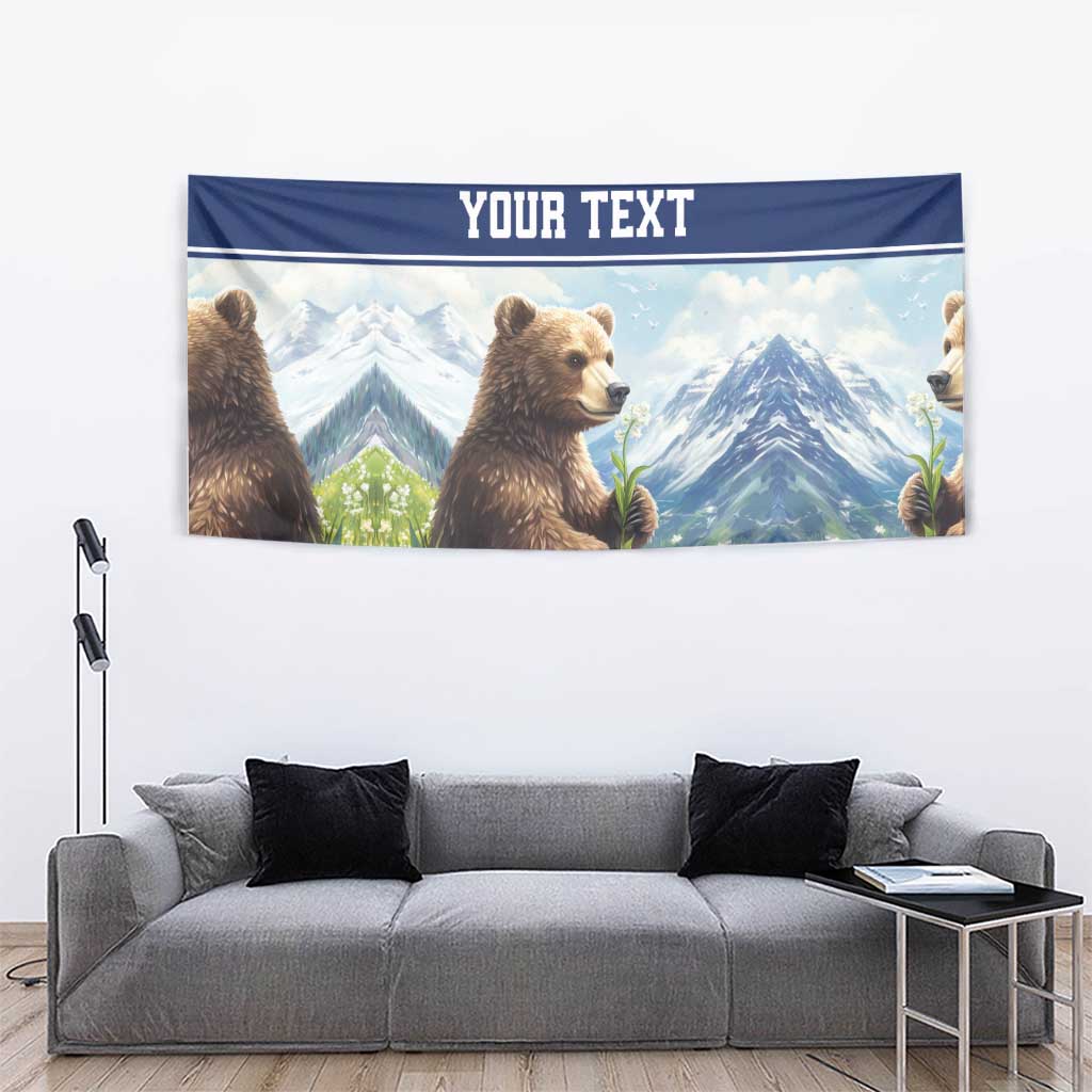 Personalized bear and mountain tapestry with blue 'YOUR TEXT' stripe and wildflowers.