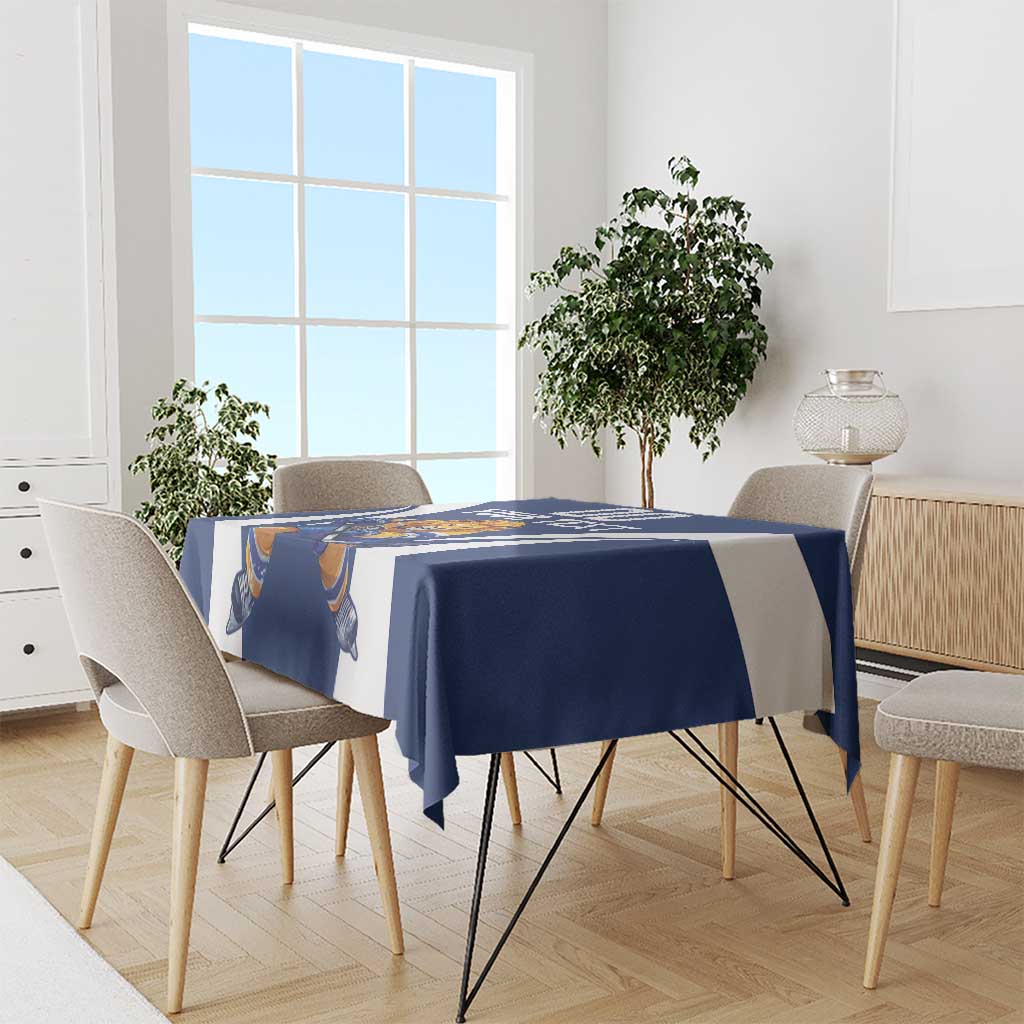 Blue hockey tablecloth with white curved graphics and lion mascot, draped over dining table