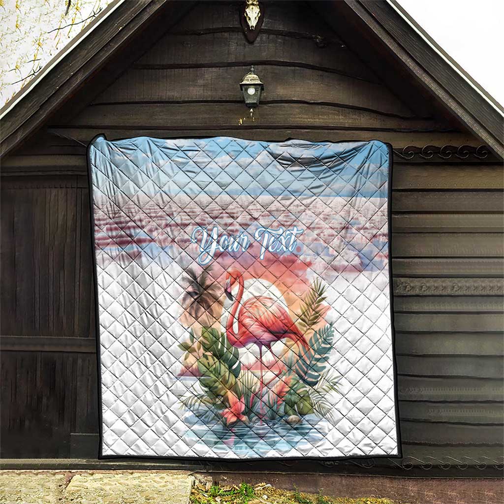 White personalized flamingo quilt with light-blue top band, tropical foliage, "Your Text" centered.