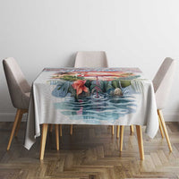 Tropical tablecloth with flamingo and palm leaves on a dining table with chairs