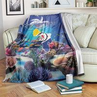Blue coral reef blanket draped over couch, fish and corals with 'YOUR TEXT' print