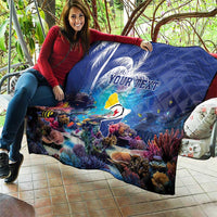 Blue personalized coral reef quilt with sea fish and custom text, laid out on patio